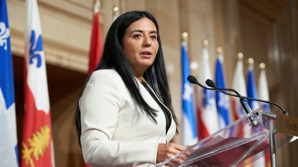 Soraya Martinez Ferrada devant les drapeaaux de Montréal et du Québec lors de son assermentation à l'hôtel de ville.
