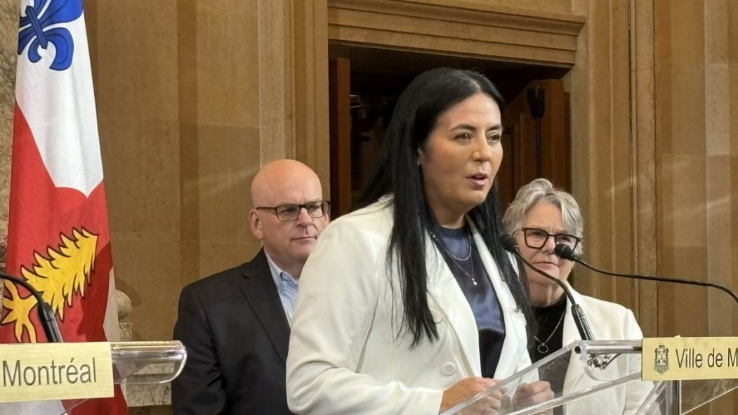 Soraya Martinez Ferrada debout devant Claude Pinard et Chantal Rouleau lors d'un point de presse.