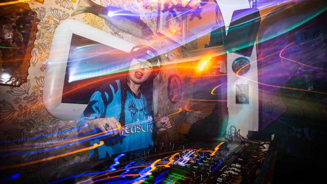 Um DJ joue de la musique derrière sa table.