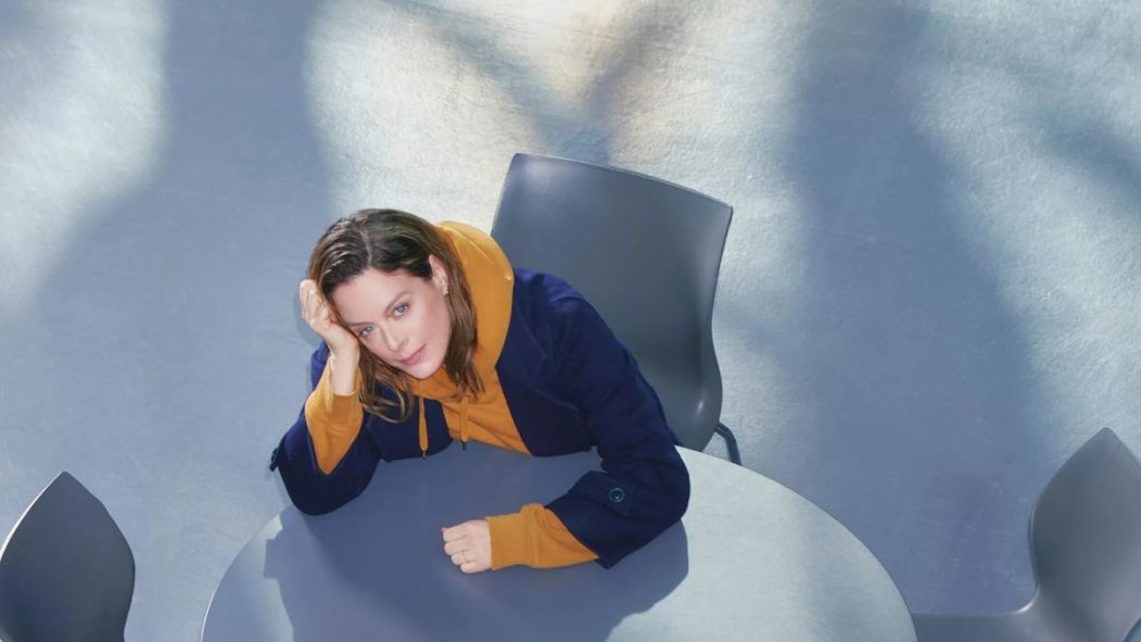 La comédienne Julie Le Breton assise à une table, vue d'en haut, dans l'affiche de la pièce de théâtre Passion simple.