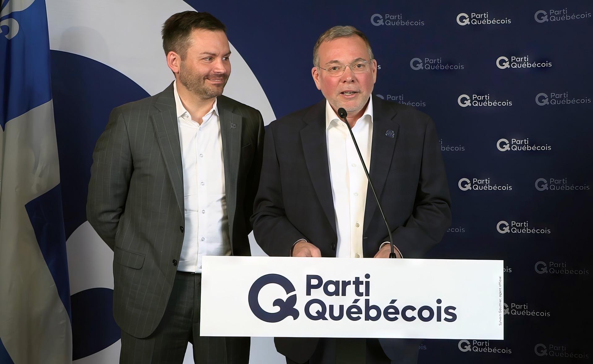 Philippe Schnobb et Paul St-Pierre Plamondon debouts devant un mur aux couleurs du PQ.