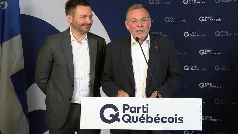 Philippe Schnobb et Paul St-Pierre Plamondon debouts devant un mur aux couleurs du PQ.