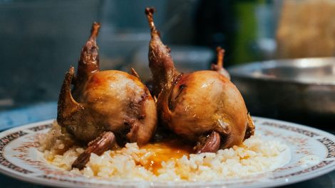 Deux cailles nappées de sauce et servies sur un lit de riz au restaurant Cécile.
