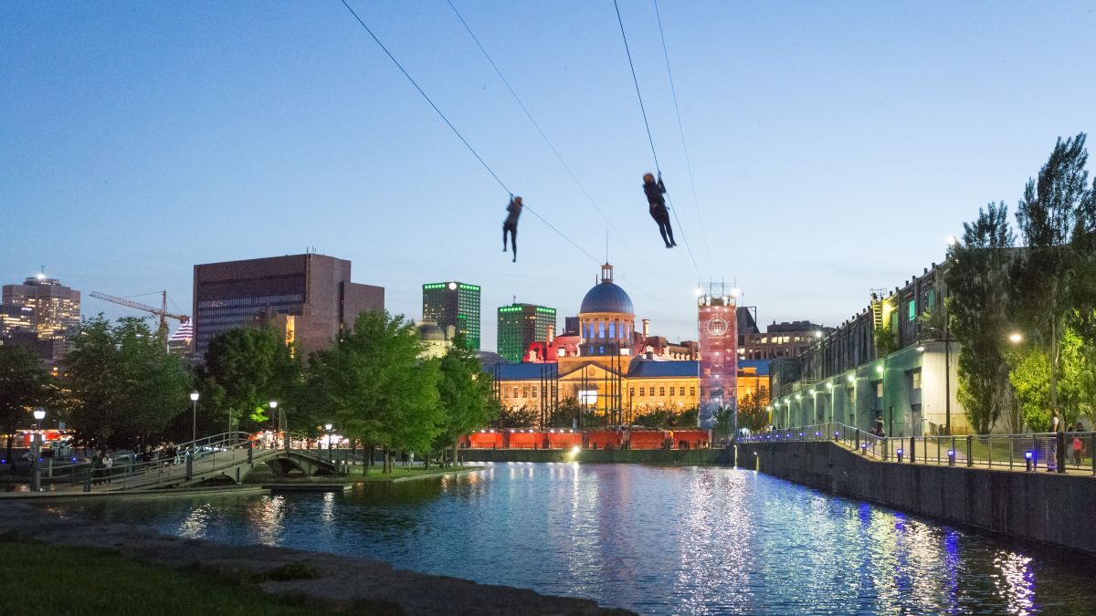 Deux personnes descendent la tyrolienne MTL Zipline vers le Marché Bonsecours.