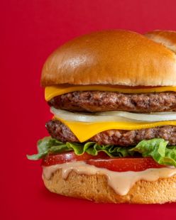 Un burger de la chaîne Ashton, sur fond rouge.