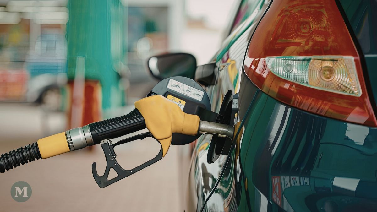 Une pompe à essance insérée dans une voiture pour faire le plein.