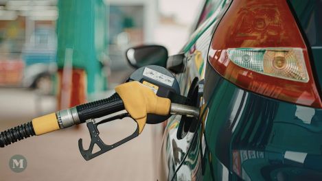Une pompe à essance insérée dans une voiture pour faire le plein.