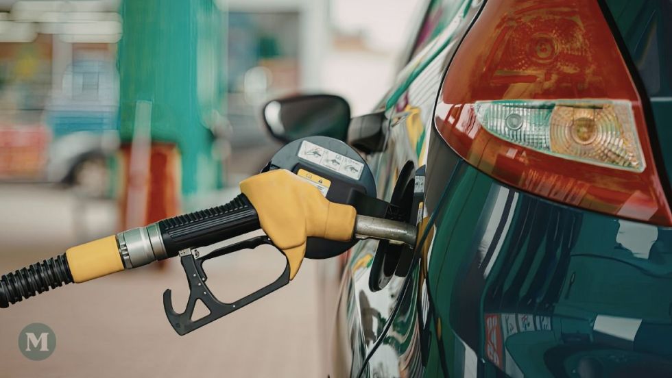 Une pompe à essance insérée dans une voiture pour faire le plein.