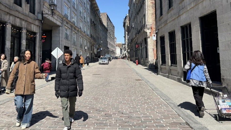 Des personnes marchent dans la rue sur le pavé de la rue Saint-Paul, après les travaux de réaménagement qui en ont fait une rue partagée.