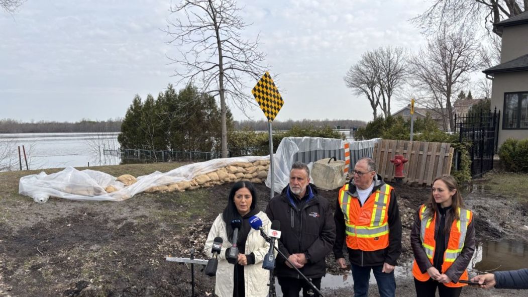 Soraya Martinez Ferrada et Jim Beis devant une digue naturelle retenant la crue des eaux de la rivière des Prairies.