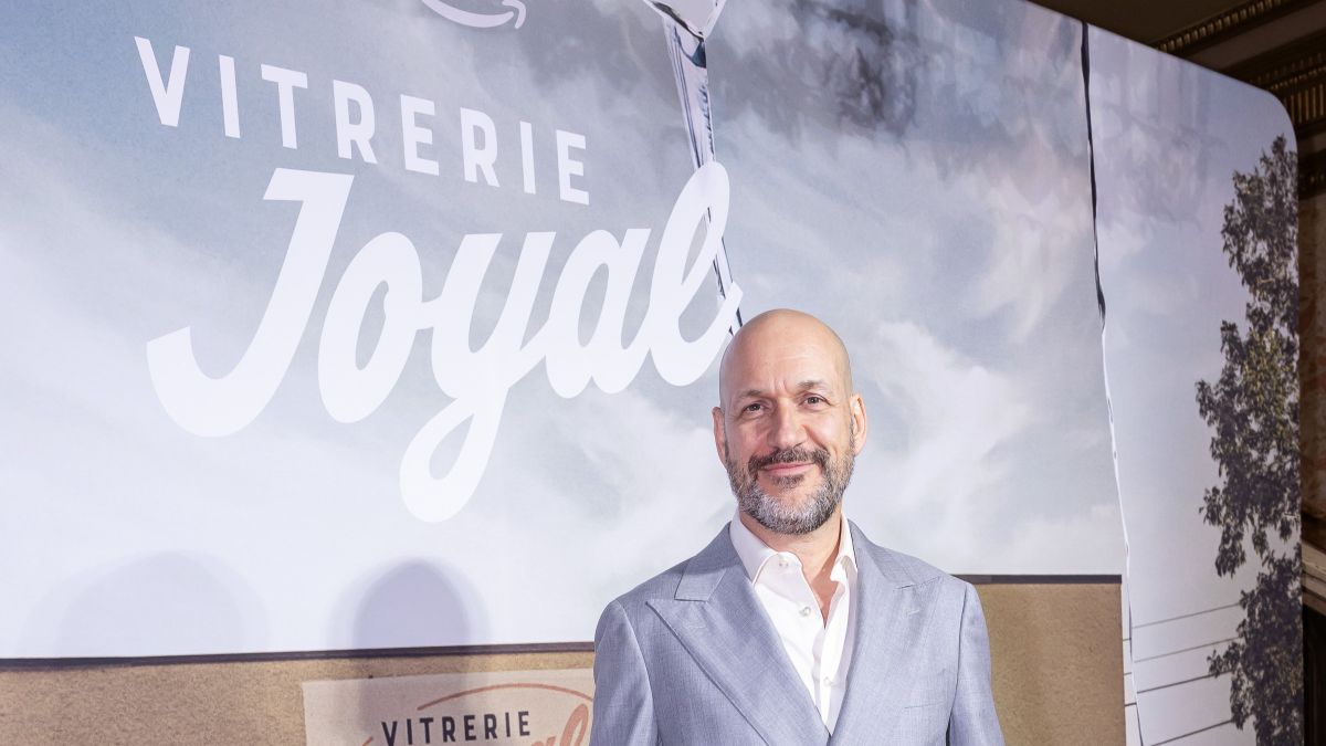Martin Matte devant l'affiche de &laquo;Vitrerie Joyal&raquo; lors de la premi&egrave;re m&eacute;diatique de la s&eacute;rie.