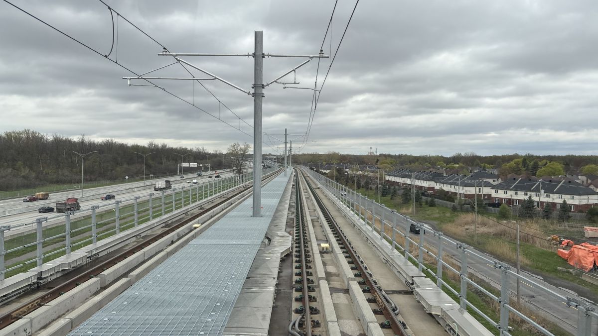 Les rails de l'antenne Anse-à-l'Orme du REM, vues du train, le long de l'autoroute 40.