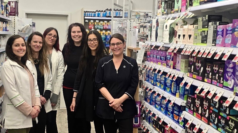 Six employées de la pharmacie Familiprix Jean-Maurice Weibel dans l'allée des produits menstruels.