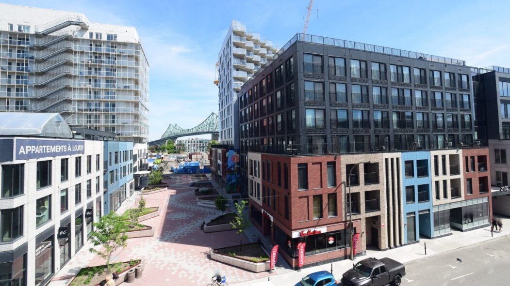 Le chantier du projet Esplanade Cartier en date du 8 juillet 2026. L'image montre deux édifices complétés avec une allée aménagée.