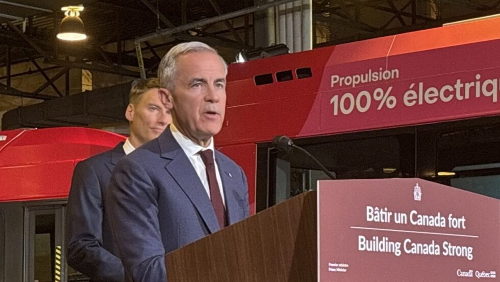 Mark Carney derrière un lutrin dans un garage du RTL.