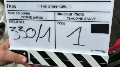 Un clap de tournage montrant le nom de la série "L'Autre fille".
