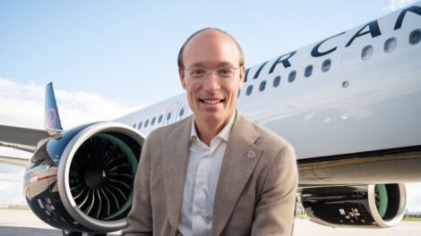 Anko Van Der Werff, PDG d'Air Canada, devant un avion affichant le logo du transporteur aérien.