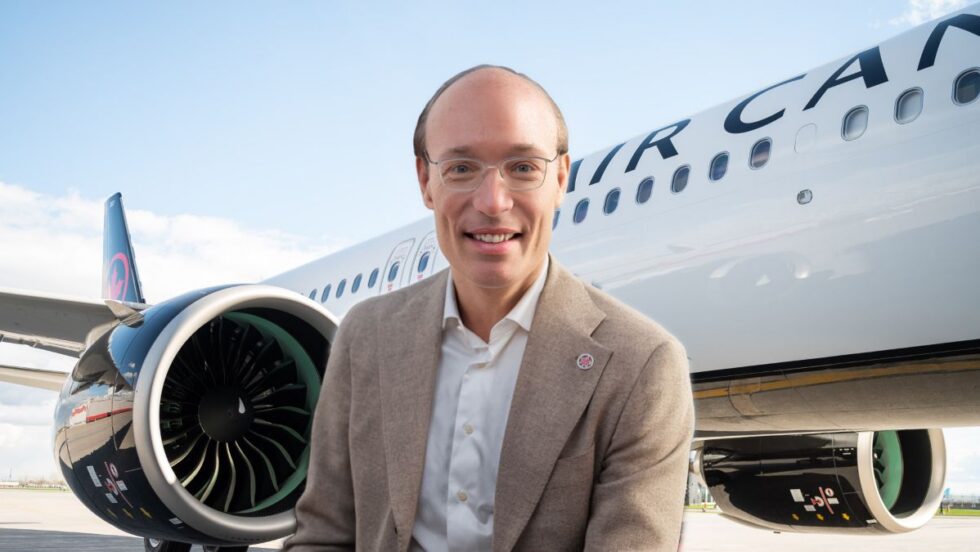 Anko Van Der Werff, PDG d'Air Canada, devant un avion affichant le logo du transporteur aérien.