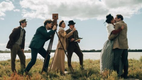 Deux personnes s'embrassent devant un photographe dans une scène de la série ALICE.