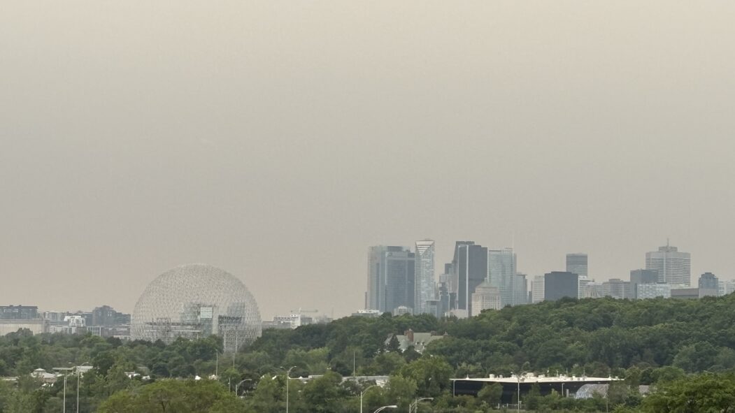 Vue du skyline de Montréal à partir de Longueuil, alors que le ciel est ennuagé et l'air est jaunis par les feux de forêt de l'Ontario.