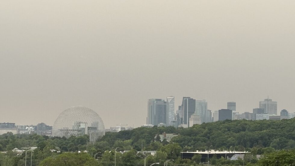 Vue du skyline de Montréal à partir de Longueuil, alors que le ciel est ennuagé et l'air est jaunis par les feux de forêt de l'Ontario.