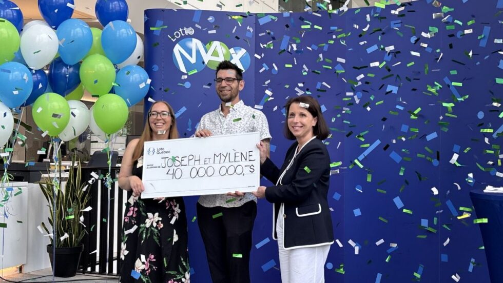 Les gagnants du gros lot Lotto Max tiennent un chèque de 40 M$ devant des balons et des confettis.