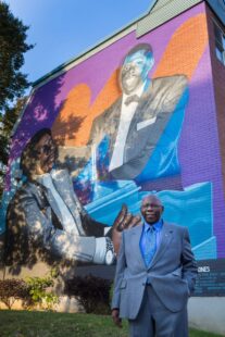 Oliver Jones devant une murale de lui-même dans la Petite-Bourgogne.