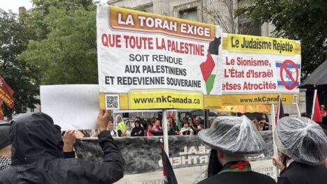 Deux Juifs orthodoxes tiennent des affiches réclamant que le territoire d'Israël soit remis aux Palestiniens au nom de la Torah, lors d'une manifestation pro-palestinienne à Montréal.