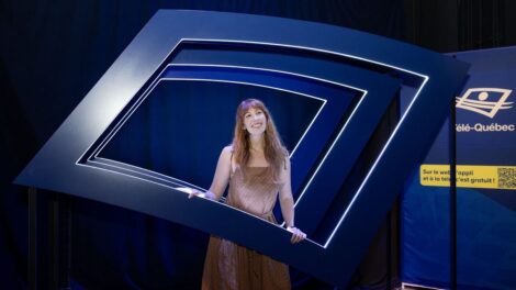 Une animatrice devant le logo de Télé-Québec.