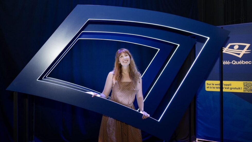 Une animatrice devant le logo de Télé-Québec.