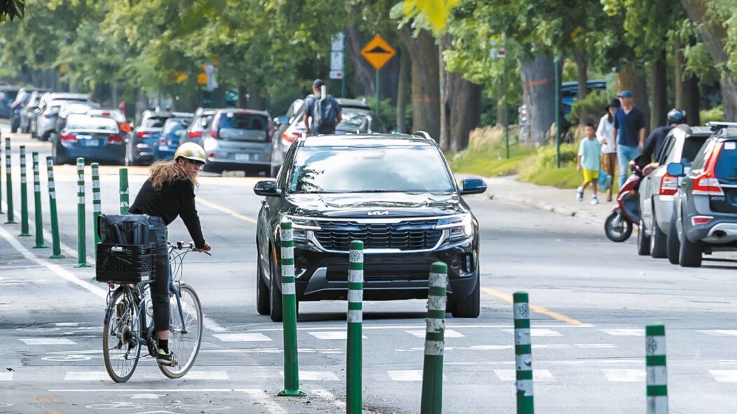 Une cycliste traverse la rue à la sortie d'une piste cyclable dans Outremont.