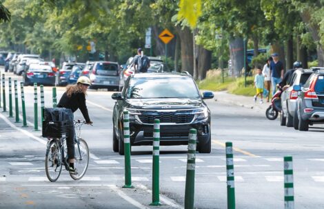 Une cycliste traverse la rue à la sortie d'une piste cyclable dans Outremont.