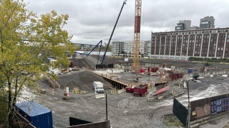 Une grue et des véhicules sont à pied d'oeuvre dans une partie du chantier du Quartier Molson.