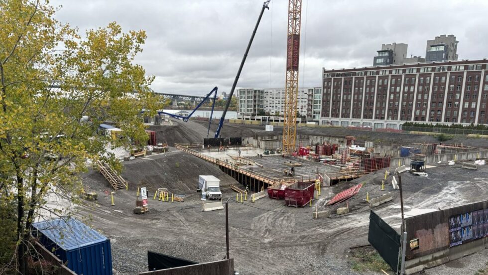 Une grue et des véhicules sont à pied d'oeuvre dans une partie du chantier du Quartier Molson.