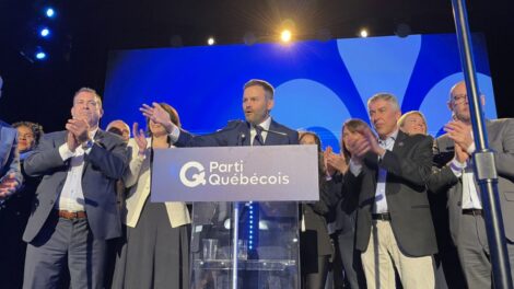 Paul St-Pierre Plamondon sur scène pendant son discours de victoire, accompagné de candidats du Parti québécois.