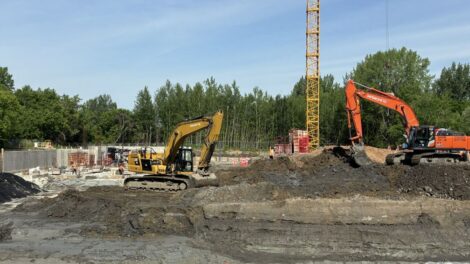 Une grue et des pelles mécaniques s'affairent sur un chantier de construction de logements dans Pointe-aux-Trembles.